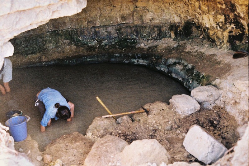 Yashar delinating Ein Sapir Spring's margin with rocks in th early days of the work